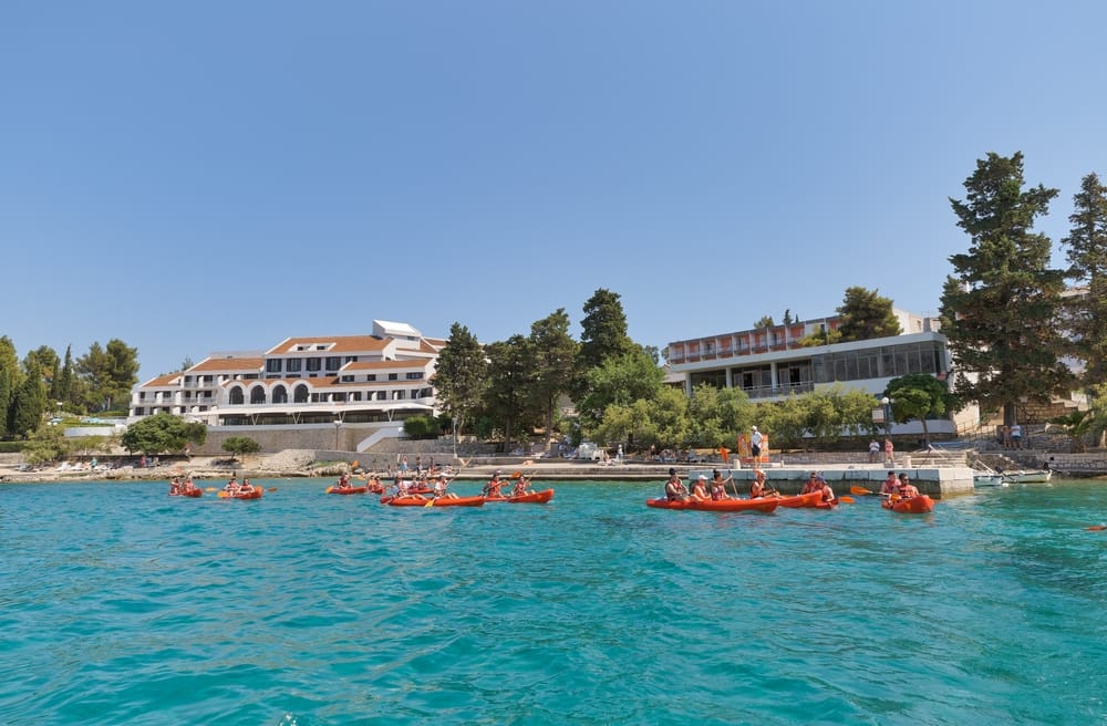 Group of kayakers with tourists paddle along the coast of Korcula Island